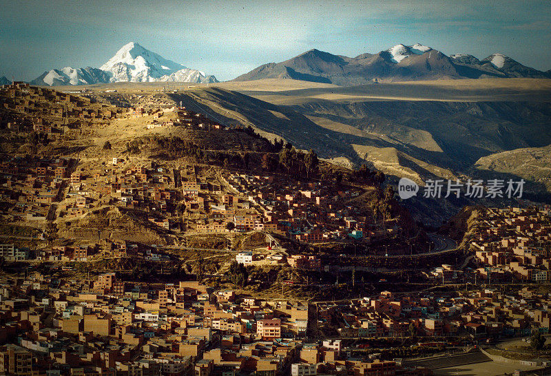 位于玻利维亚拉巴斯的Macrodistrito Maximiliano Paredes，一个以山脉为背景的小镇上的房屋